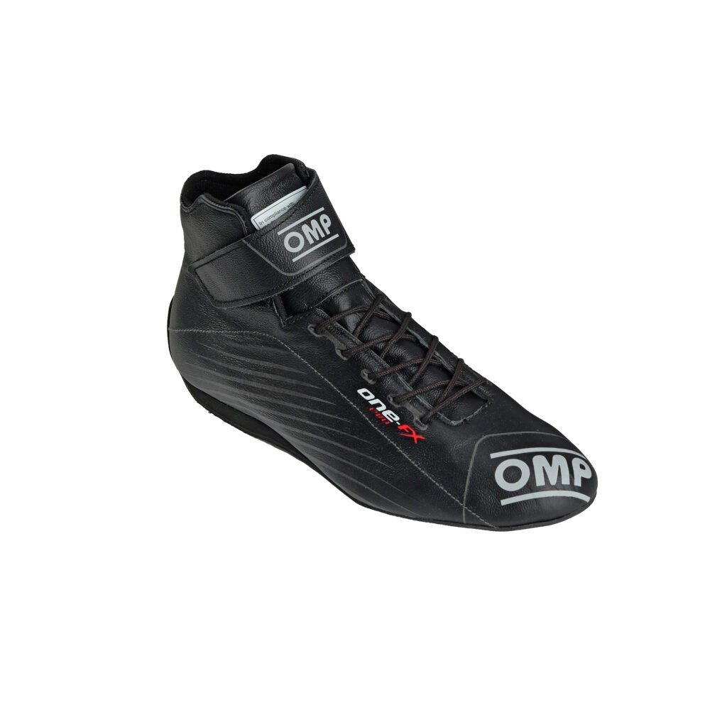 Black OMP One-FX high-top racing shoes with an adjustable ankle strap, lightweight fire-retardant construction, and professional grip sole. Black OMP One-FX high-top racing shoes with an adjustable ankle strap, lightweight fire-retardant construction, and professional grip sole.